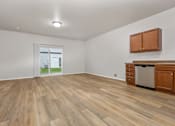 Thumbnail 22 of 60 - A room with wooden flooring and a window showing a view of a house.