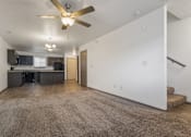Thumbnail 26 of 59 - A spacious living room with a ceiling fan and a carpeted floor.