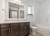 Thumbnail 8 of 47 - A bathroom with a white toilet and a white bathtub.