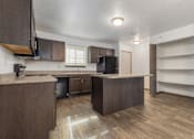 Thumbnail 13 of 59 - A kitchen with brown cabinets and a wooden floor.