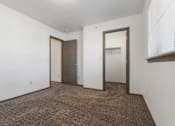 Thumbnail 29 of 59 - A room with brown carpet and white walls with two doors.
