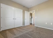 Thumbnail 43 of 54 - A room with two white doors and a carpeted floor.