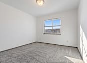 Thumbnail 36 of 47 - A room with a carpeted floor and a window overlooking a building.
