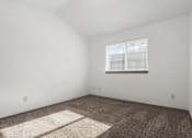 Thumbnail 33 of 59 - A room with a carpet and a window.
