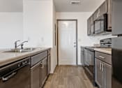 Thumbnail 23 of 47 - A kitchen with a white door and black appliances.