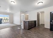 Thumbnail 38 of 50 - A spacious kitchen with dark wood floors and white walls.