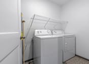 Thumbnail 35 of 58 - A white washing machine and dryer in a small laundry room.