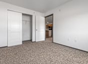Thumbnail 6 of 58 - A room with a carpeted floor and two doors.