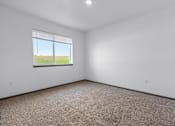Thumbnail 38 of 58 - A room with a window overlooking a field.