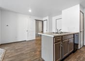 Thumbnail 39 of 58 - A kitchen with a white counter top and wooden floors.