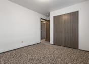 Thumbnail 14 of 59 - A room with a carpeted floor and a brown door.