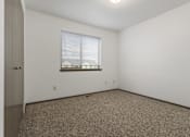 Thumbnail 39 of 59 - A room with a carpeted floor and a window with blinds.
