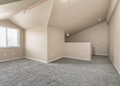 Thumbnail 25 of 40 - A spacious room with a window and a grey carpet.