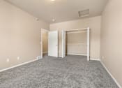 Thumbnail 26 of 40 - A large, empty room with a carpeted floor and white walls.
