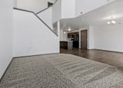 Thumbnail 19 of 57 - A room with a carpeted floor and a staircase.