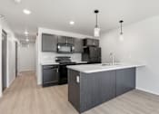 Thumbnail 25 of 68 - A modern kitchen with a large island and stainless steel appliances.