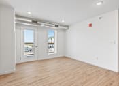 Thumbnail 11 of 44 - the living room of an apartment with white walls and wood flooring