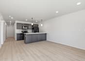 Thumbnail 32 of 68 - A modern kitchen with a wooden floor and white walls.