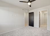 Thumbnail 29 of 68 - A room with a ceiling fan and a black door.