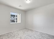 Thumbnail 37 of 68 - A room with a window and carpeted floor.