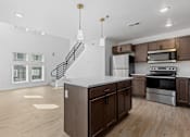 Thumbnail 13 of 44 - a kitchen with an island and stainless steel appliances and wooden cabinets