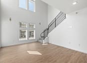 Thumbnail 15 of 44 - an empty living room with white walls and wood flooring and a staircase