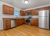 Thumbnail 15 of 60 - A kitchen with wooden cabinets and stainless steel appliances.