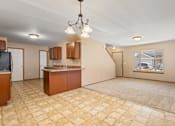 Thumbnail 2 of 64 - A kitchen area with a tile floor and a chandelier hanging from the ceiling.