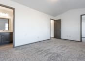 Thumbnail 39 of 47 - A spacious room with a grey carpet and a wooden door.