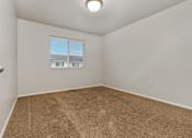 Thumbnail 57 of 60 - A room with a carpeted floor and a window with blinds.