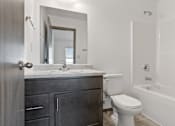 Thumbnail 40 of 47 - A bathroom with a toilet, sink, and bathtub.