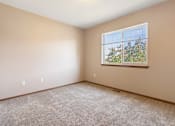 Thumbnail 14 of 64 - A room with a window showing trees outside.
