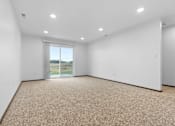 Thumbnail 14 of 54 - A large empty room with a carpeted floor and a window.