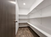 Thumbnail 22 of 47 - A hallway with a brown door and white walls.