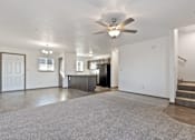 Thumbnail 42 of 47 - A spacious living room with a grey carpet and a ceiling fan.