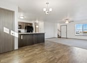 Thumbnail 43 of 47 - A spacious living room with a kitchen area in the background.
