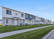Thumbnail 9 of 47 - A row of houses with a sidewalk in front.