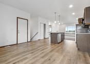 Thumbnail 54 of 54 - A kitchen with a wooden floor and white walls.