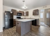Thumbnail 15 of 50 - A kitchen with a black refrigerator, microwave, and stove top oven.