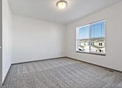 Thumbnail 45 of 47 - A room with a carpeted floor and a window showing a view of other buildings.