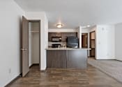 Thumbnail 5 of 47 - A kitchen with a wooden floor and white walls.