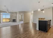 Thumbnail 4 of 54 - A spacious living room with a fireplace and a kitchen area with a countertop and cabinets.