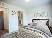Thumbnail 1 of 21 - A bedroom with a large bed and a clock on the wall.