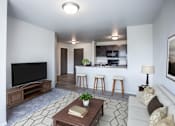 Thumbnail 2 of 21 - A living room with a television, a couch, and a coffee table.