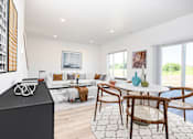 Thumbnail 8 of 54 - A modern living room with a white couch, a wooden table, and a large window.