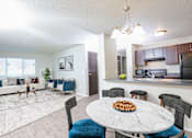 Thumbnail 1 of 18 - A modern living room with a dining table set for two.