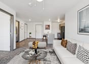 Thumbnail 1 of 21 - A modern living room with a white sofa and a glass coffee table.