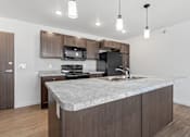 Thumbnail 28 of 44 - a kitchen with a marble counter top and wooden cabinets