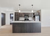 Thumbnail 45 of 68 - A modern kitchen with a dark wood island and stainless steel appliances.