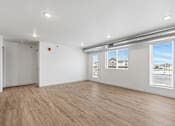 Thumbnail 31 of 44 - the living room of an apartment with a wood floor and white walls